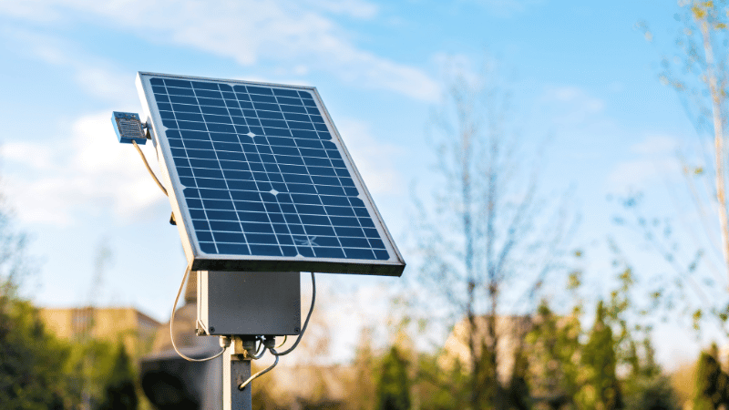 A small, stand-alone solar panel against a blue sky, representing sustainable and renewable business en-ergy solutions.